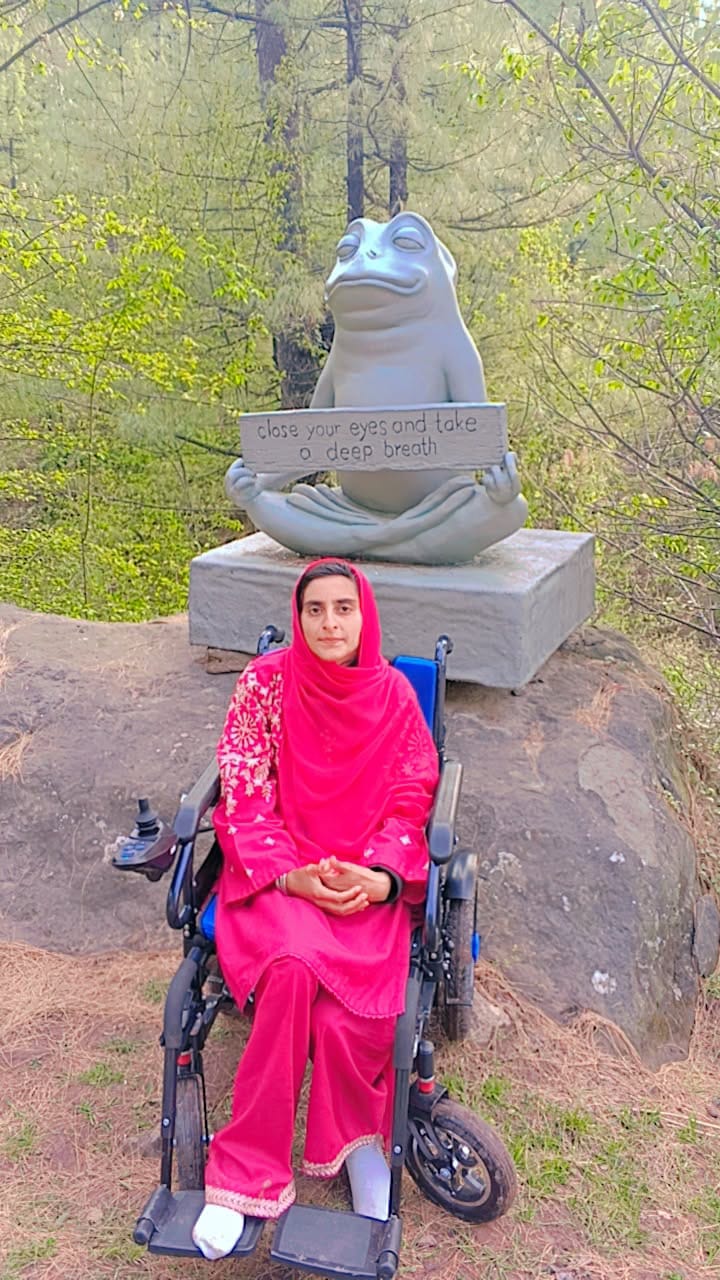 Momina Abbasi, who runs Mazoor Foundation, in her powered wheelchair on a wooded hillside.