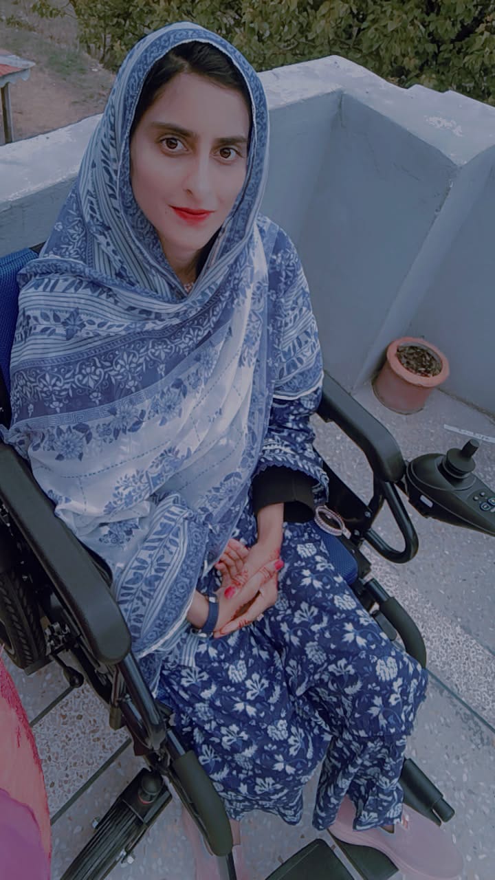 Momina Abbasi in her powered wheelchair on a rooftop terrace.